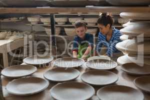 Female potter assisting a boy
