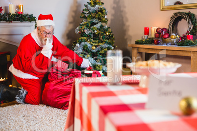 Santa Claus putting presents in christmas bag