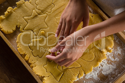 Man removing gingerbread dough on wooden table