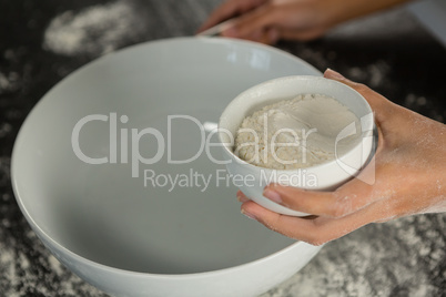 Woman holding bowl with flour