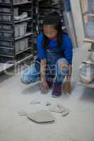 Girl looking at broken pieces of plate