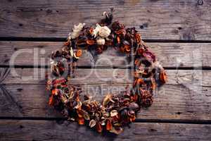 Dried flowers forming circle on wooden plank
