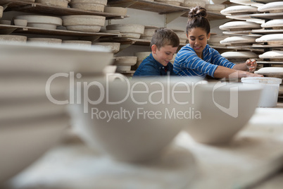 Female potter assisting a boy