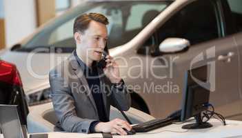 Sales talking on phone while using computer
