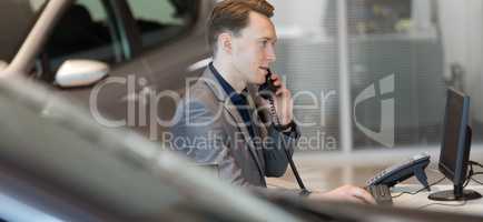 Salesman talking on landline phone in showroom