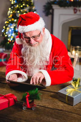 Santa Claus using digital tablet on table