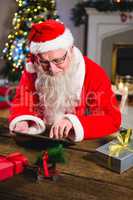 Santa Claus using digital tablet on table