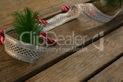 High angle view of candy canes with ribbon and pine needles on table