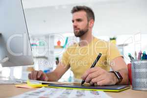 Male executive working over graphic tablet at her desk