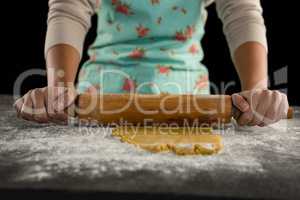 Woman baking dough with rolling pin