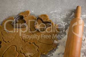 Gingerbread dough with flour, cookie cutter and rolling pin