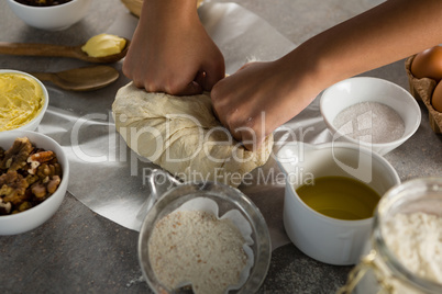 Woman preparing dough surrounded with various ingredients