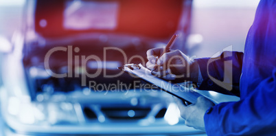 Close up of a man writing on a clipboard