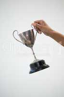 Hand holding a trophy against white background