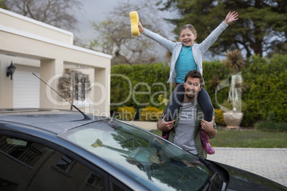 Teenage girl and father washing a car