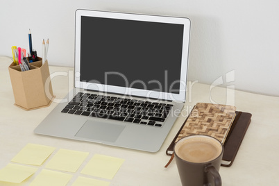 Laptop and various office accessories on table