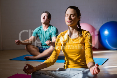 People meditating in lotus position at club