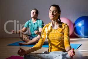 People meditating in lotus position at club