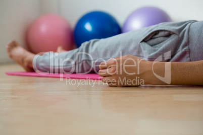 Low section of woman exercising while lying on mat Low section of woman exercising while lying on mat