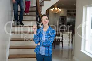 Woman holding house key while sitting