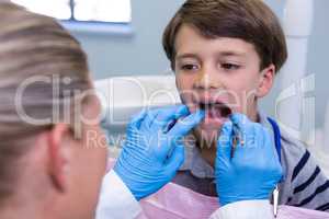 Close up of dentist examining boy