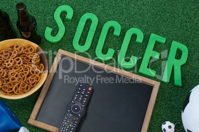 Chalkboard, snacks and football on artificial grass