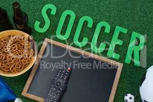 Chalkboard, snacks and football on artificial grass