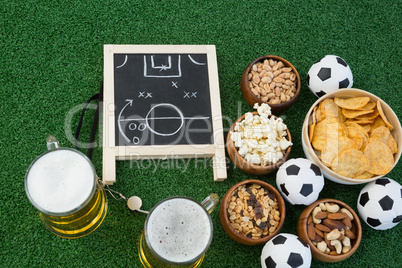 Strategy board, football and snacks on artificial grass