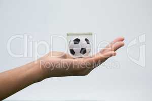 Hand holding acrylic football cube against white background