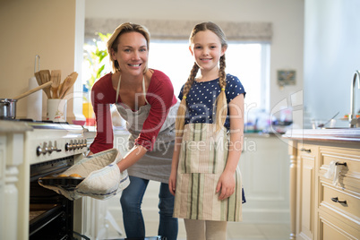 Mother and daughter preparing cup cake in kitchen