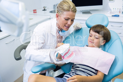 Dentist holding dental mould while talking with boy