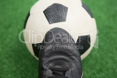 Football and cleats on artificial grass