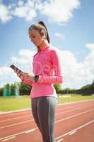 Woman using mobile phone on a race track