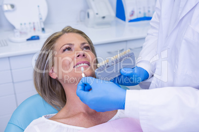 Doctor holding tooth whitening equipment by patient