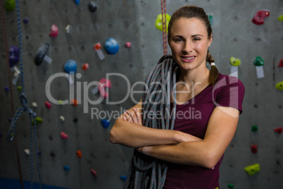 Portrait of smiling athlete with rope standing in gym