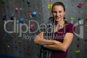 Portrait of smiling athlete with rope standing in gym
