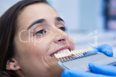Close up of dentist holding equipment while examining woman at clinic