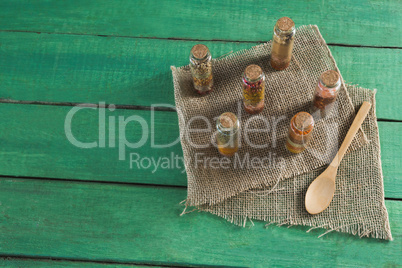 Various spices in bottles on wooden table