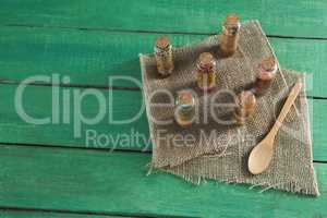 Various spices in bottles on wooden table