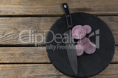 Sliced onions and knife on chopping board