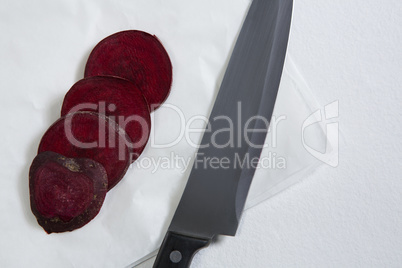 Sliced beetroots and knife on white background