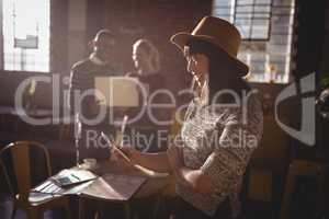 Smiling woman using smartphone against colleauges