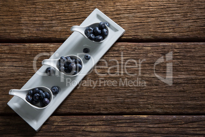 Blueberries in spoon arranged on tray