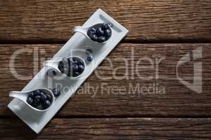 Blueberries in spoon arranged on tray