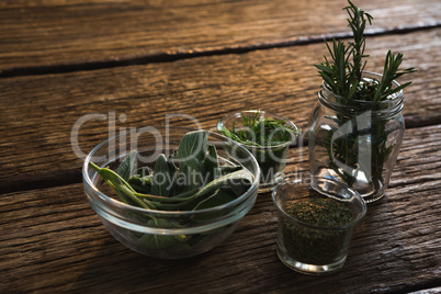 Various herbs in a jar on wooden table