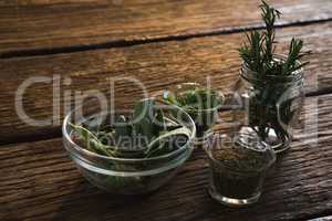 Various herbs in a jar on wooden table