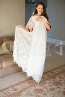 Smiling bride trying on dress while standing in living room