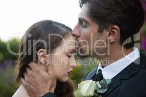 Bridegroom kissing on bride forehead