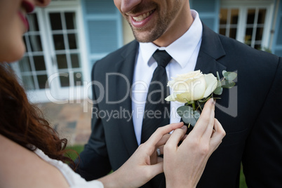 Midsection of bride adjusting rose on bride blazer