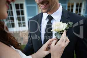 Midsection of bride adjusting rose on bride blazer